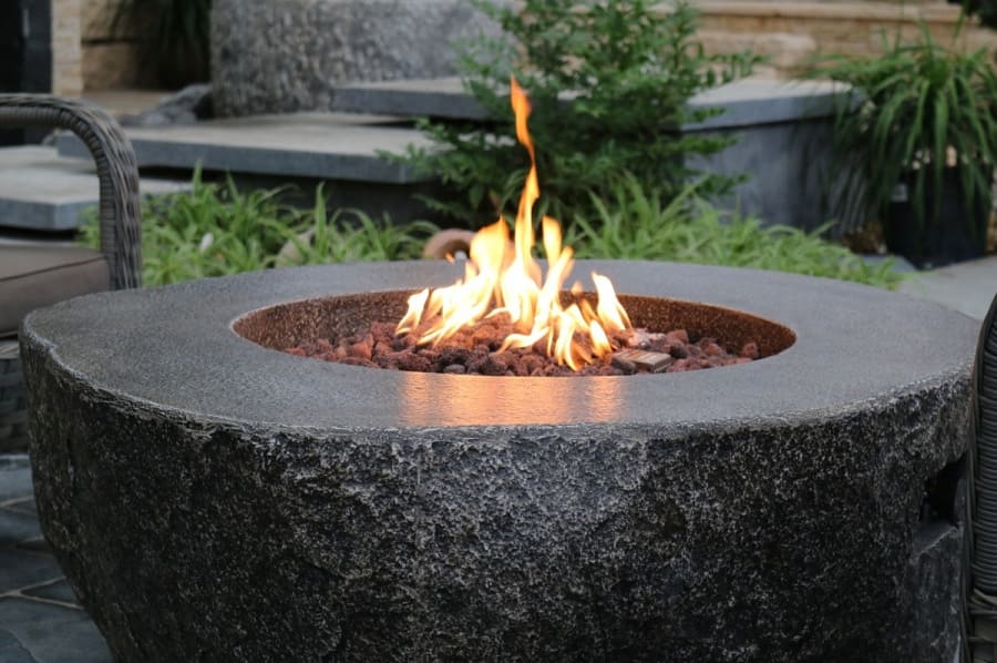 Mesa de jardín con chimenea en forma de chimenea de gas de piedra.